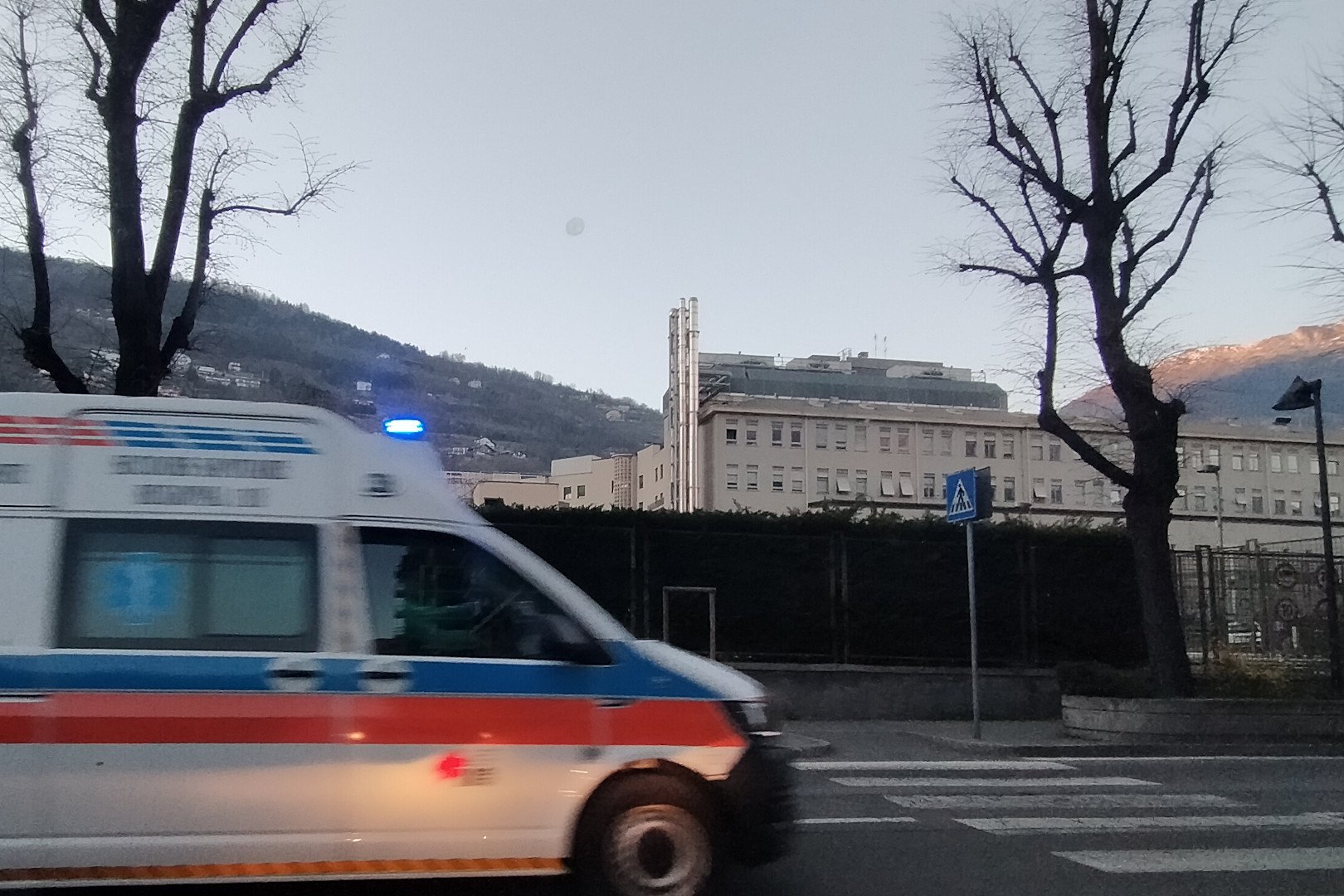 Un'ambulanza corre verso l'ospedale (sullo sfondo)