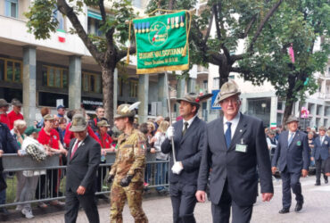 Il presidente dell'Ana Valle d'Aosta con lo stendardo ufficiale in apertura della sfilata del gruppo valdostano all'Adunata nazionale 2025 di Biella