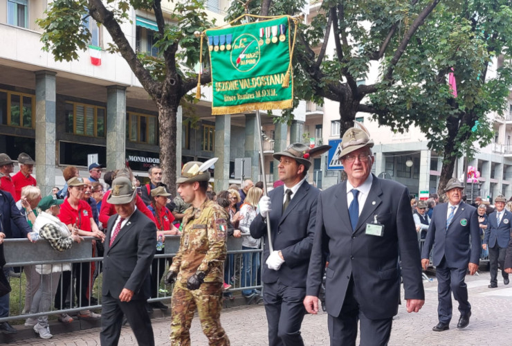 Il presidente dell'Ana Valle d'Aosta con lo stendardo ufficiale in apertura della sfilata del gruppo valdostano all'Adunata nazionale 2025 di Biella
