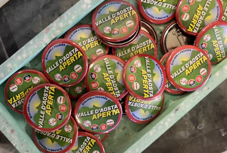 Le vecchie spille di Valle d'Aosta aperta, con i simboli di Area Democratica, ADU VdA, Sinistra Italiana e Movimento 5 Stelle
