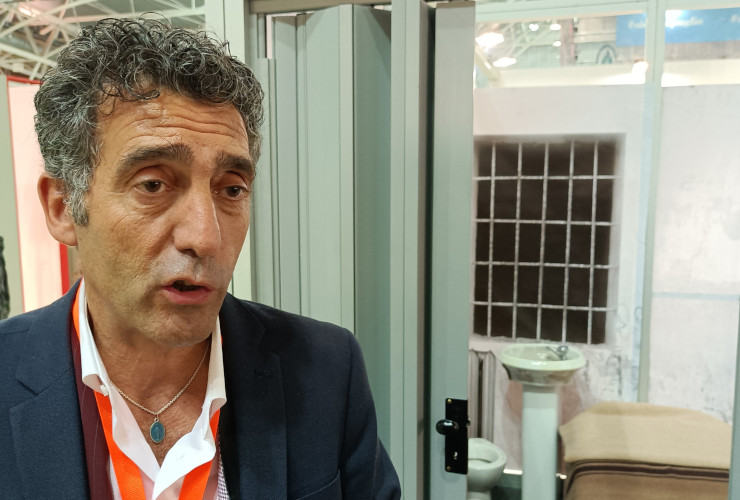 Marco Sorbara davanti alla riproduzione della cella in cui è stato detenuto, al Salone del libro di Torino del 2023
