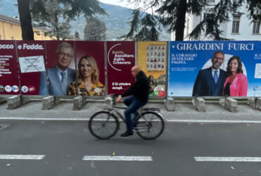 I manifesti per il ballottaggio di Rocco e Girardini davanti alla pista ciclabile, in piazza della Repubblica ad Aosta