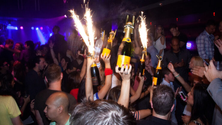 Bottiglie di champagne con candele scintillanti in un locale