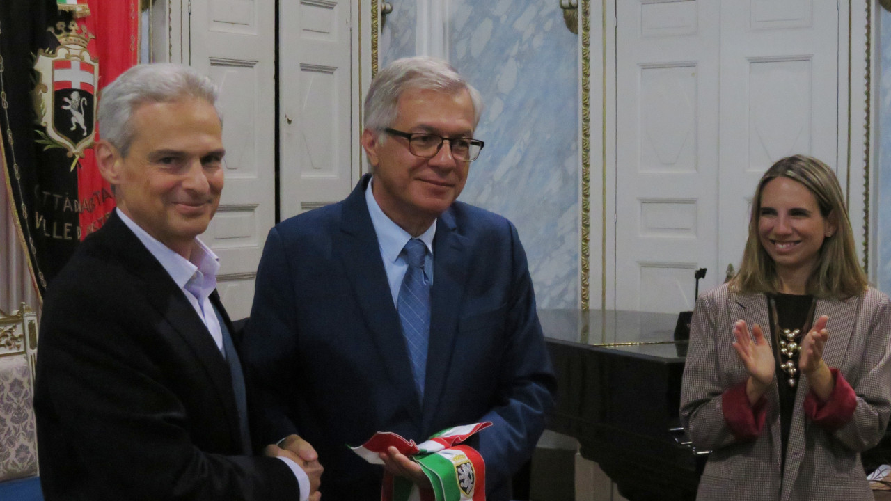 Gianni Nuti passa la fusciacca di sindaco a Raffaele Rocco con Valeria Fadda che applaude