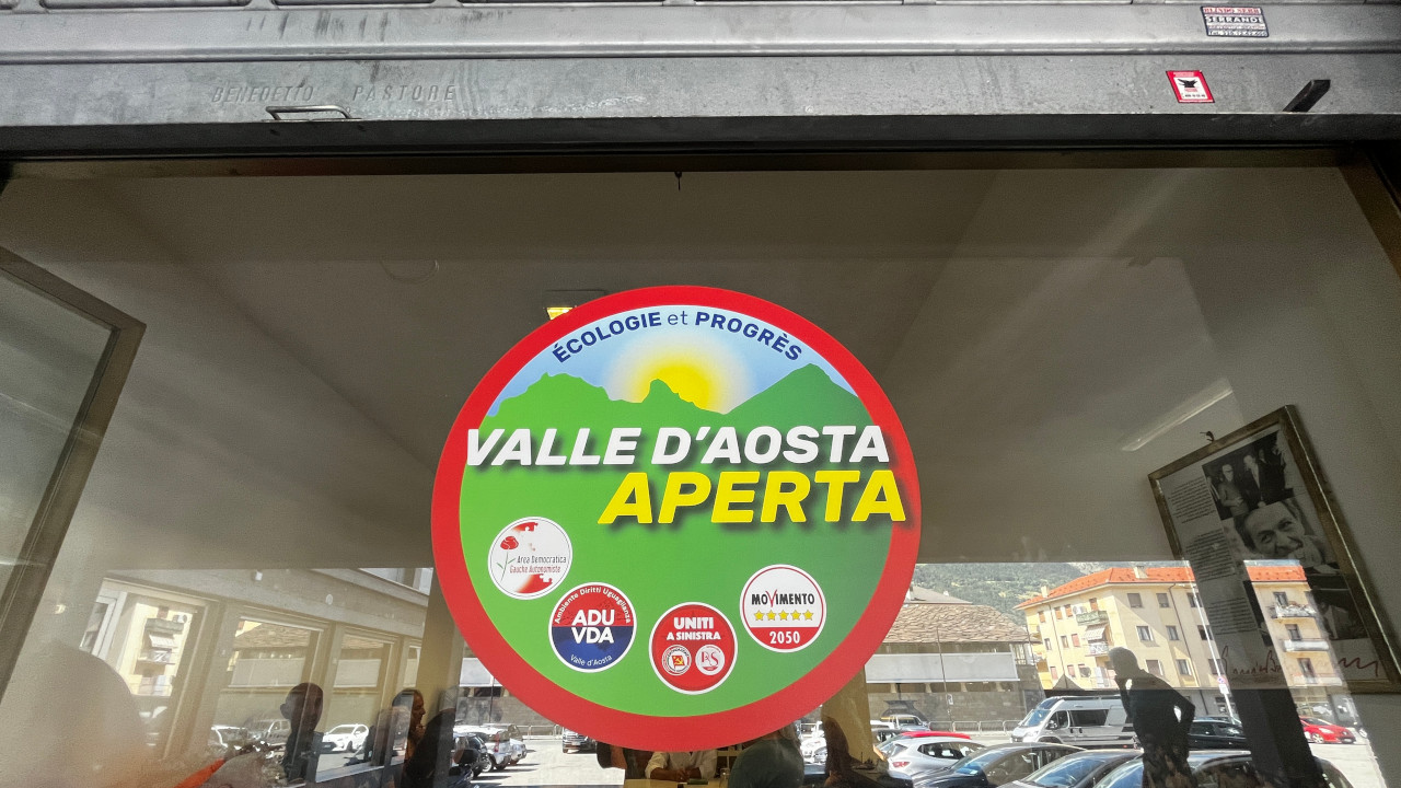 Il logo di Valle d'Aosta Aperta nella vetrina della sede aostana