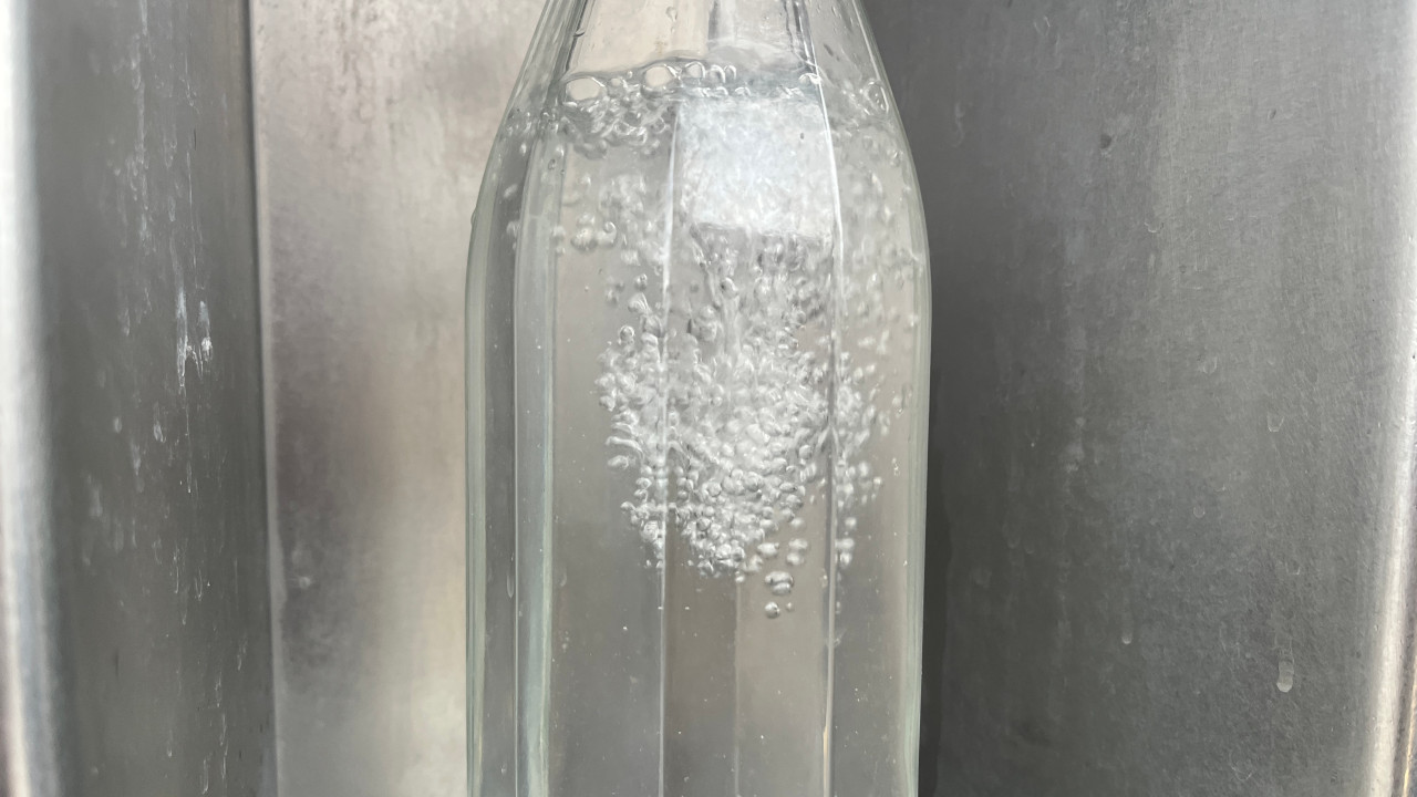 Il riempimento di una bottiglia in una Casa dell'acqua