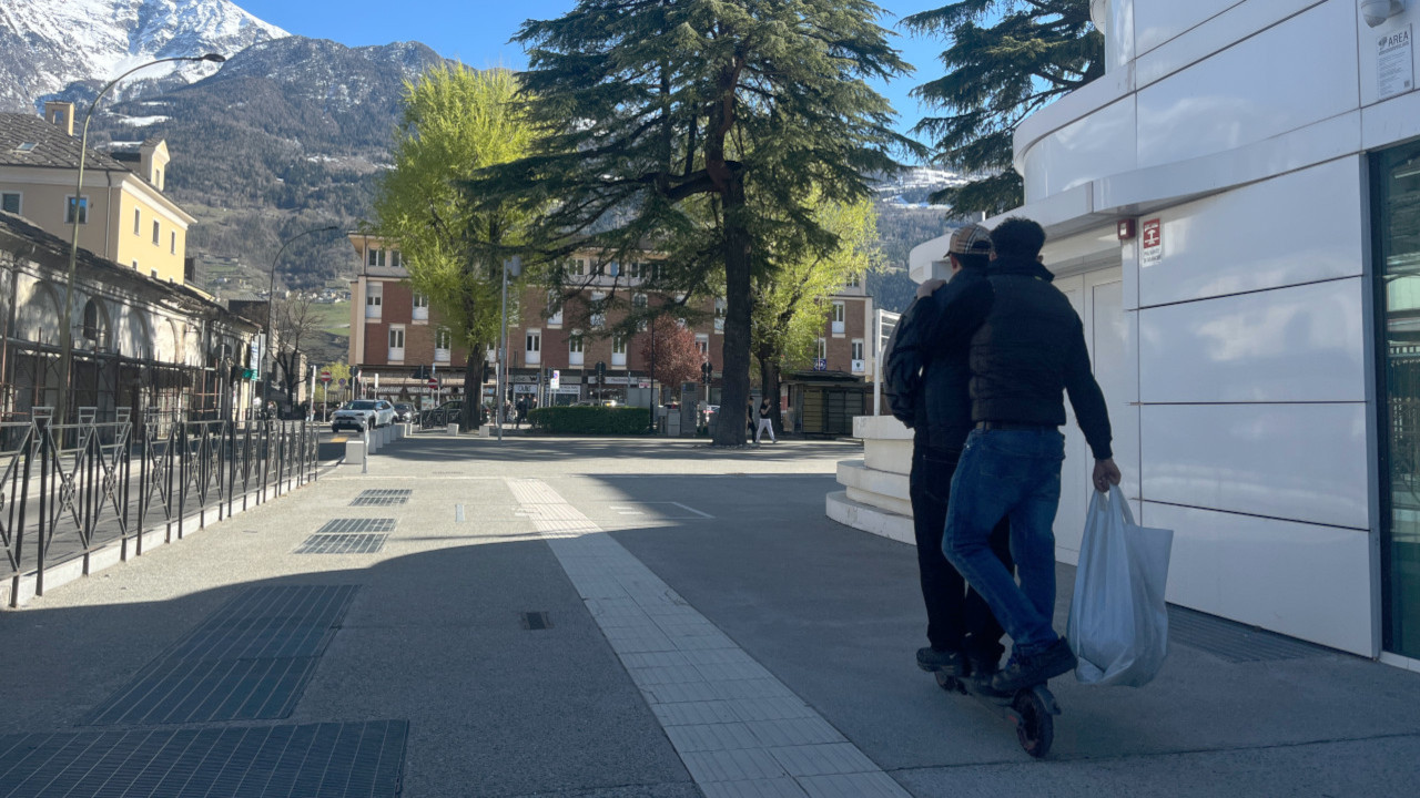 Due persone in monopattino sul marciapiede dell'Università